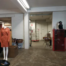 Winkelvloer met kledingrekken, stellingen, mannequin en diverse spullen in kringloopwinkel
