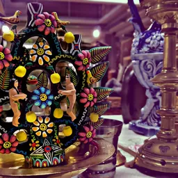 Kleurrijk versierde houten decoratief object met bloemen, figuren en sieraden op donkere ondergrond