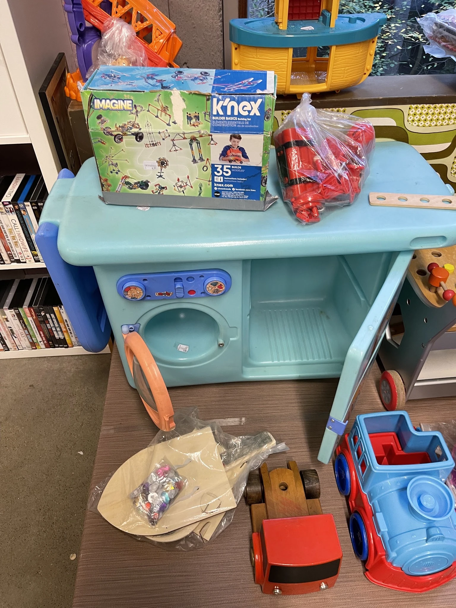 Speelgoed wasserette set in lichtblauw met wasmachine en droger, opgesteld in een winkelruimte