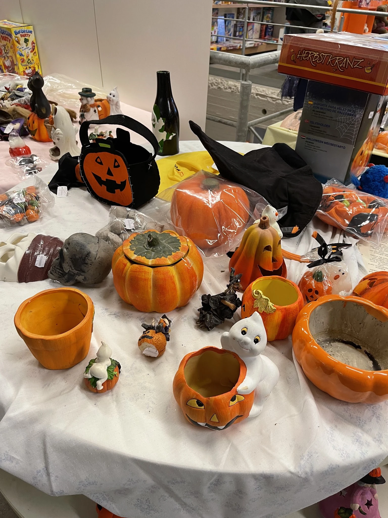 Halloweendecoratie en servies: pompoenen, spoken, heksenmutsen en thematische items uitgestald op tafel