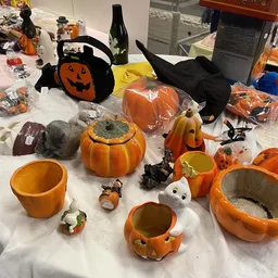 Halloweendecoratie en servies: pompoenen, spoken, heksenmutsen en thematische items uitgestald op tafel