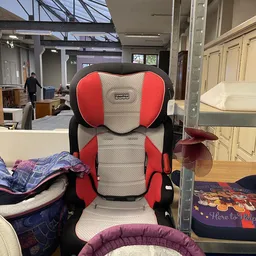 Rode en grijze autostoelverhoger close-up in een kringloopwinkel