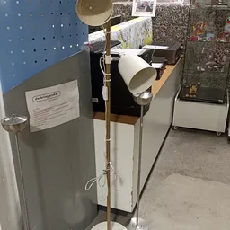 Winkelinterieur met stellingen, lampen en diverse artikelen; blauwe wand en textielstukken zichtbaar