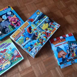 Verzameling tweedehands speelgoed en bordspellen op houten vloer