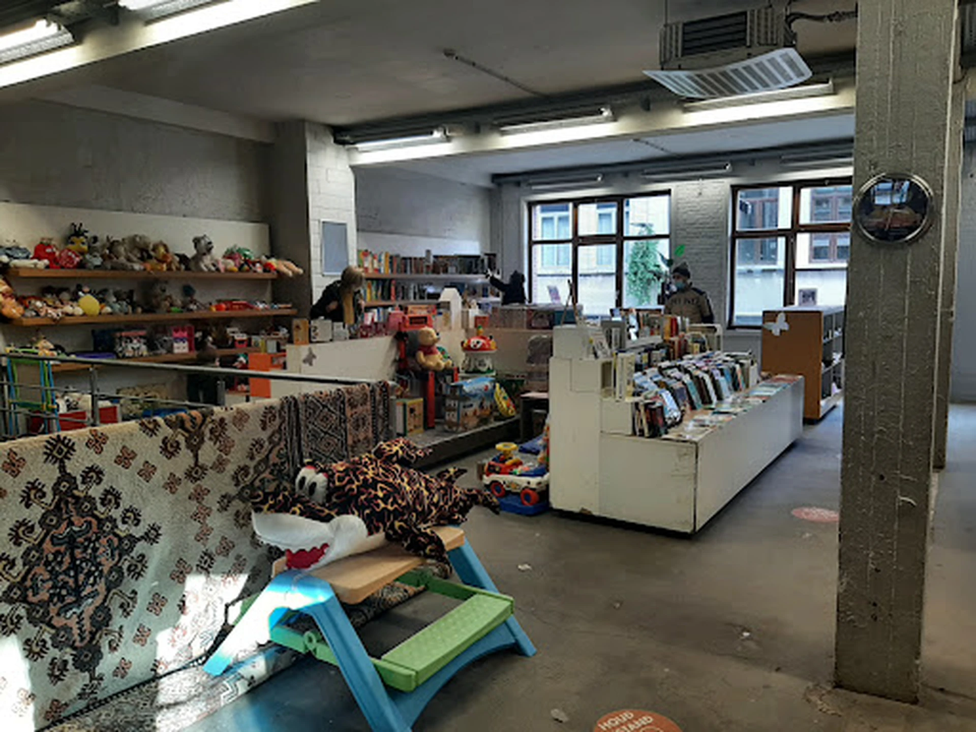 Winkelvloer van een kringloopwinkel met stellingen, textiel, boeken en diverse tweedehandsartikelen