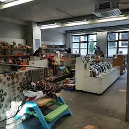 Winkelvloer van een kringloopwinkel met stellingen, textiel, boeken en diverse tweedehandsartikelen
