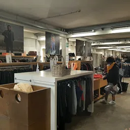 Winkelvloer met kledingrekken, toonbanken en stellingen in een kringloopwinkel