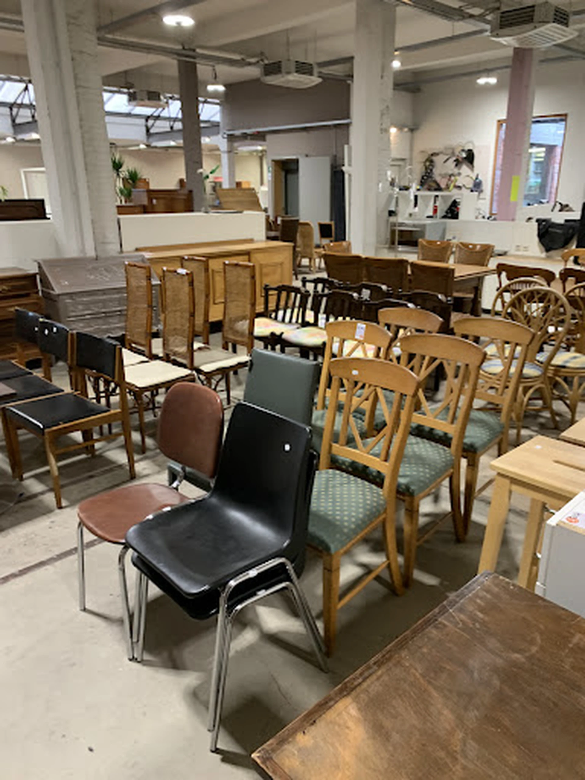 Diverse tweedehands stoelen en meubels uitgestald in de winkel