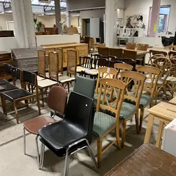 Diverse tweedehands stoelen en meubels uitgestald in de winkel