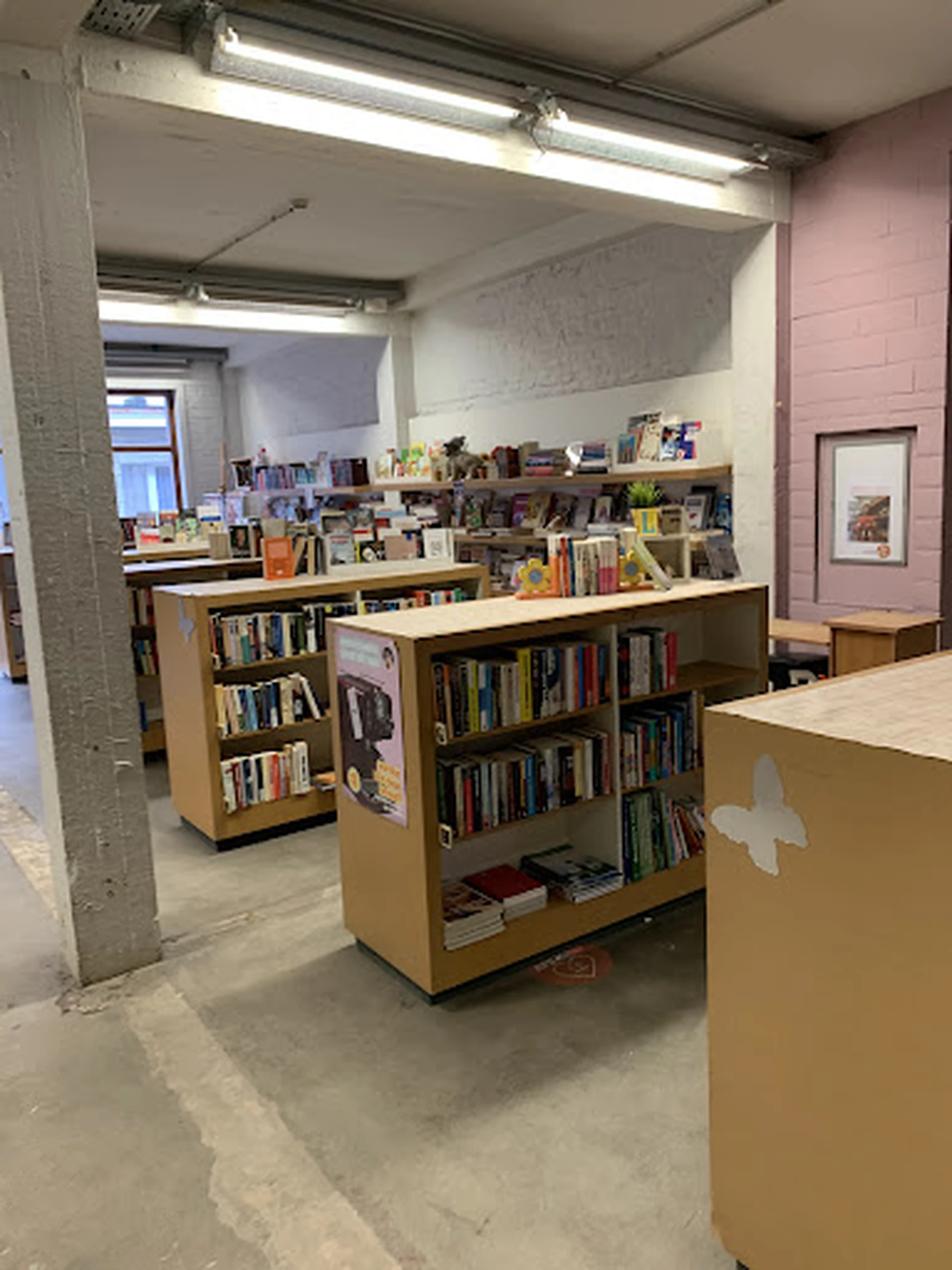 Winkelvloer met houten boekenkasten en stellingen vol tweedehands boeken en media