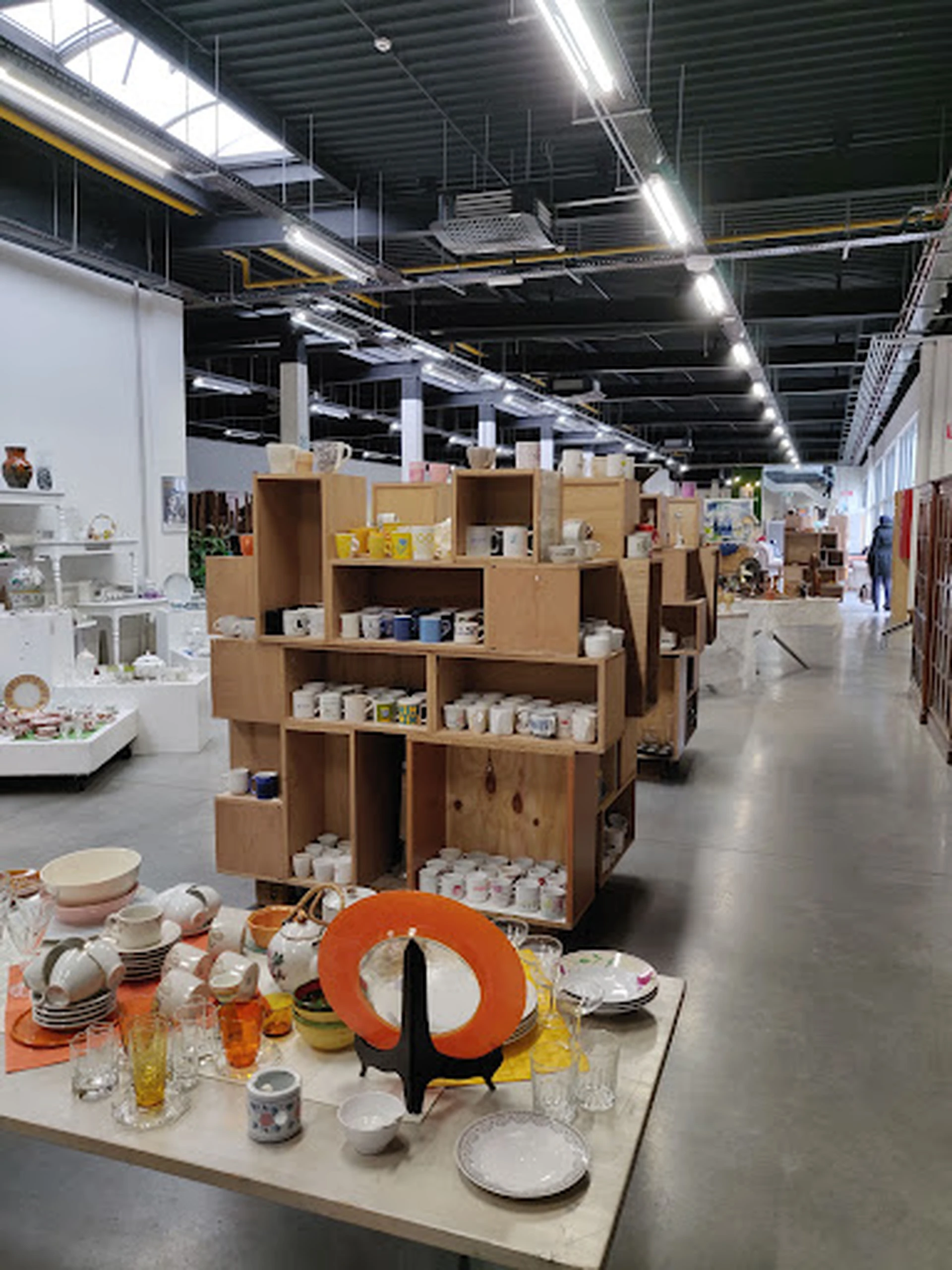 Kartonnen stellingkasten met huishoudelijke artikelen en serviesgoed in een kringloopwinkel