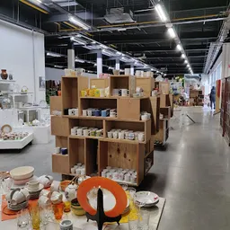 Kartonnen stellingkasten met huishoudelijke artikelen en serviesgoed in een kringloopwinkel