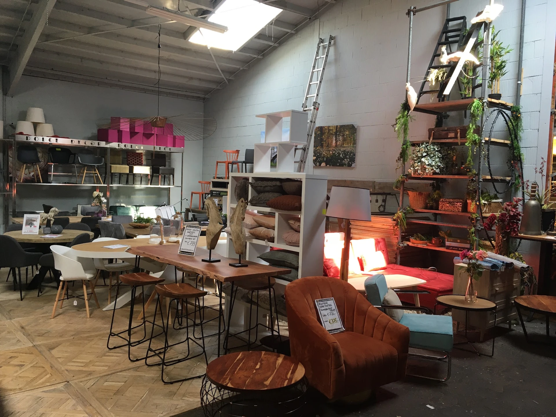 Vintage winkelbinnenruimte met meubels, planken, decoratie en verlichte zithoek met bruine fauteuil