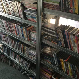 Glazen vitrinekasten met uitgestalde cd's en dvd's op meerdere niveaus