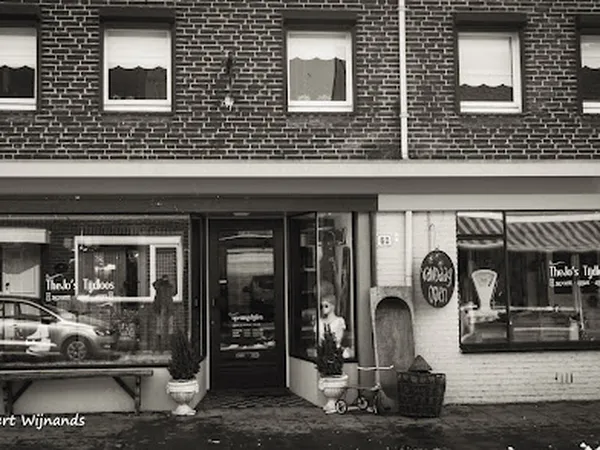 Voorgevel van kringloopwinkel TheJo's Tijdloos aan de Dorpstraat met grote ramen en zwarte deur