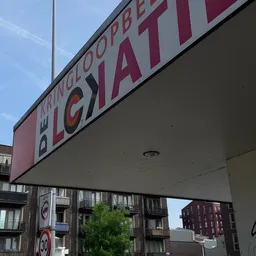 Voorkant van kringloopwinkel De Lokatie met rode en witte gevel en bordes