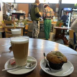 Koffie en muffin op tafel in de koffiehoek van de winkel