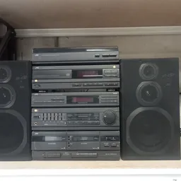 Vintage stereoinstallatie met twee luidsprekers, cassettedeck, CD-speler en tuner op een plank