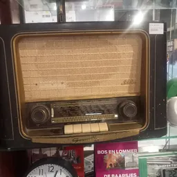 Vintage houten radio uit de jaren 1950 met beige stoffen speaker en donker houten front met knoppen