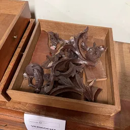 Houten ornamentale decoratie met bloemen- en bladmotieven in een houten kist