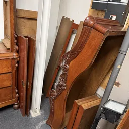 Verzameling antieke houten meubels en decorstukken, waaronder kasten en ornamentaal houtwerk