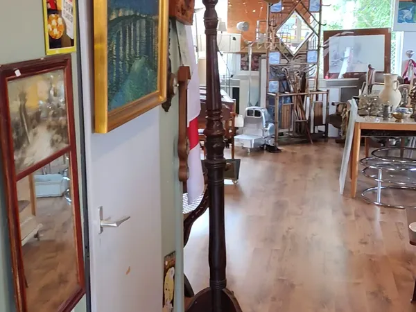 Winkelvloer van een kringloopwinkel met meubels, kunstvoorwerpen en decoratieartikelen op stellingen en tafels