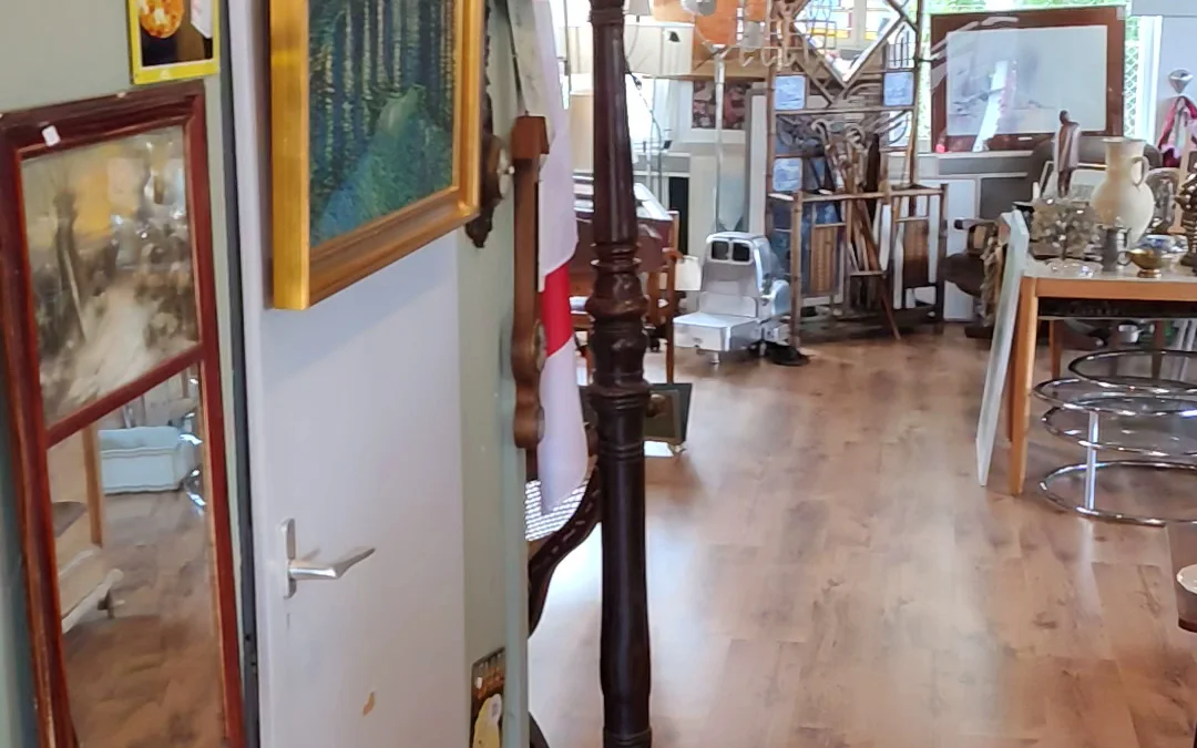 Winkelvloer van een kringloopwinkel met meubels, kunstvoorwerpen en decoratieartikelen op stellingen en tafels