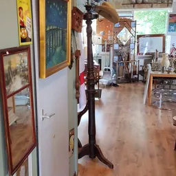 Winkelvloer van een kringloopwinkel met meubels, kunstvoorwerpen en decoratieartikelen op stellingen en tafels