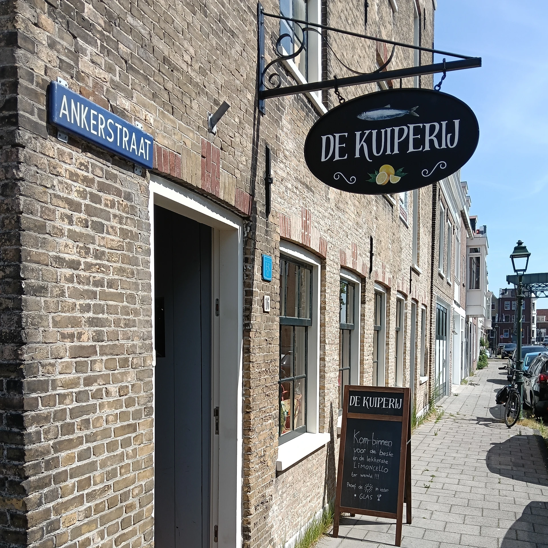 Gevel van De Kuiperij aan de Ankerstraat met zwart uithangteken en donkergroene deur