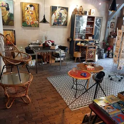 Vintage winkelinterieur met retro meubels, tafels, stoelen en decoratieve objecten onder kunstwerk aan de wand