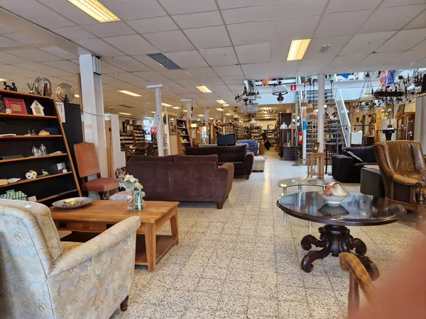 Winkelvloer met fauteuils, tafels, boekenkasten en diverse meubels en decoratie