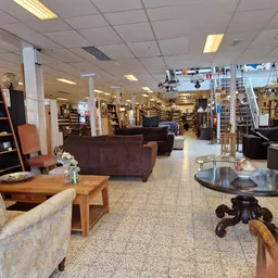 Winkelvloer met fauteuils, tafels, boekenkasten en diverse meubels en decoratie