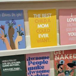 Greetingcards en posters met kleurrijke afbeeldingen en motiverende teksten op een winkelplank