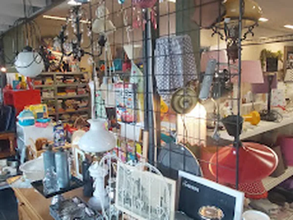 Winkelbinnenkant met hangend huishoudelijk spullen, stellingen en diverse tweedehands artikelen