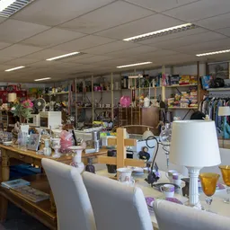 Winkelvloer van kringloopwinkel met tafels, stellingen, kleding en diverse tweedehands spullen