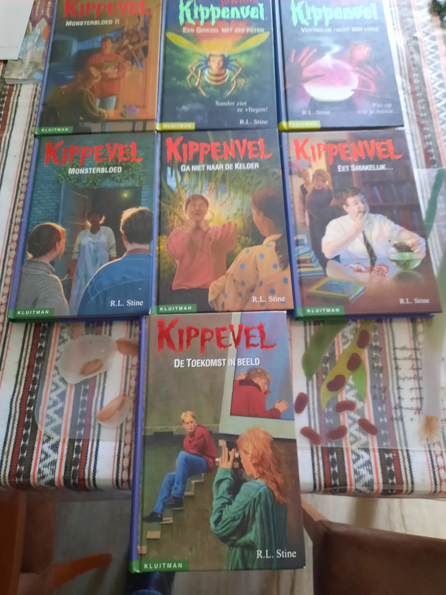 Vier boeken uit de Kippevel-serie van R.L. Stine op een gestreepte ondergrond