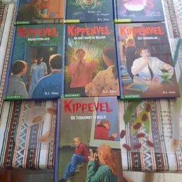 Vier boeken uit de Kippevel-serie van R.L. Stine op een gestreepte ondergrond