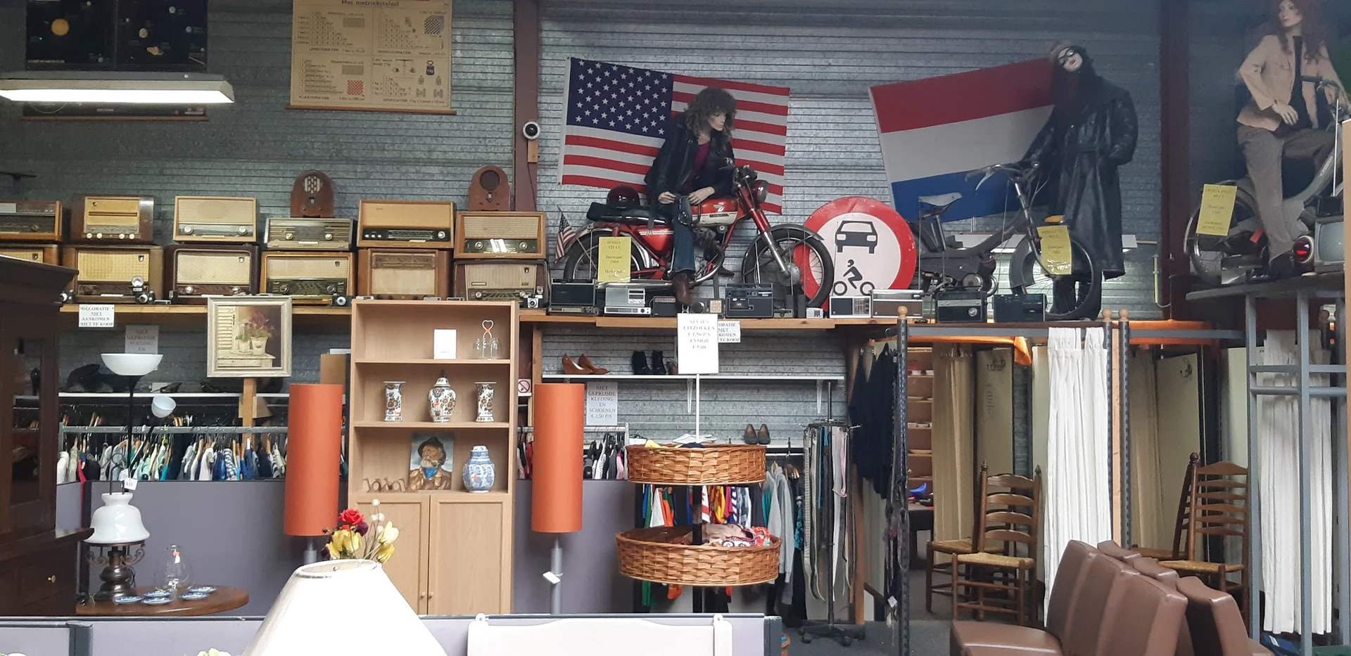 Winkelinterieur met stellingen, kleding op hangers, decoratie met Amerikaanse vlag en motorfiets op display