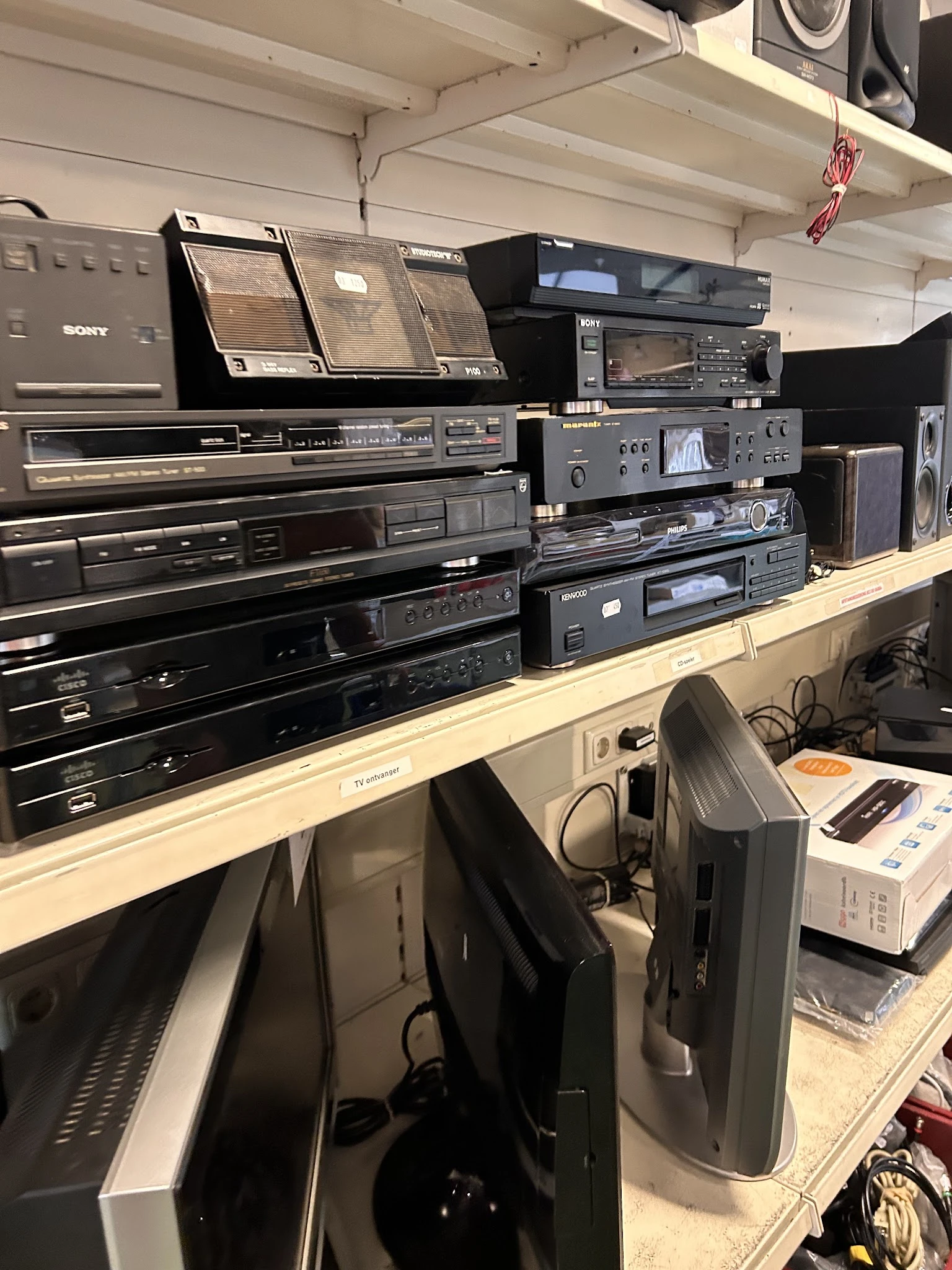 Verzameling vintage audio- en hifi-apparatuur op houten stellingen