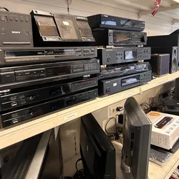 Verzameling vintage audio- en hifi-apparatuur op houten stellingen