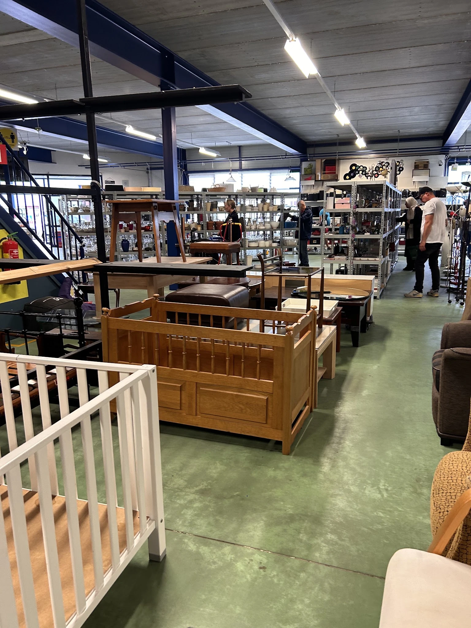 Winkelvloer met diverse meubels waaronder houten babyboxen, tafels en andere tweedehands spullen