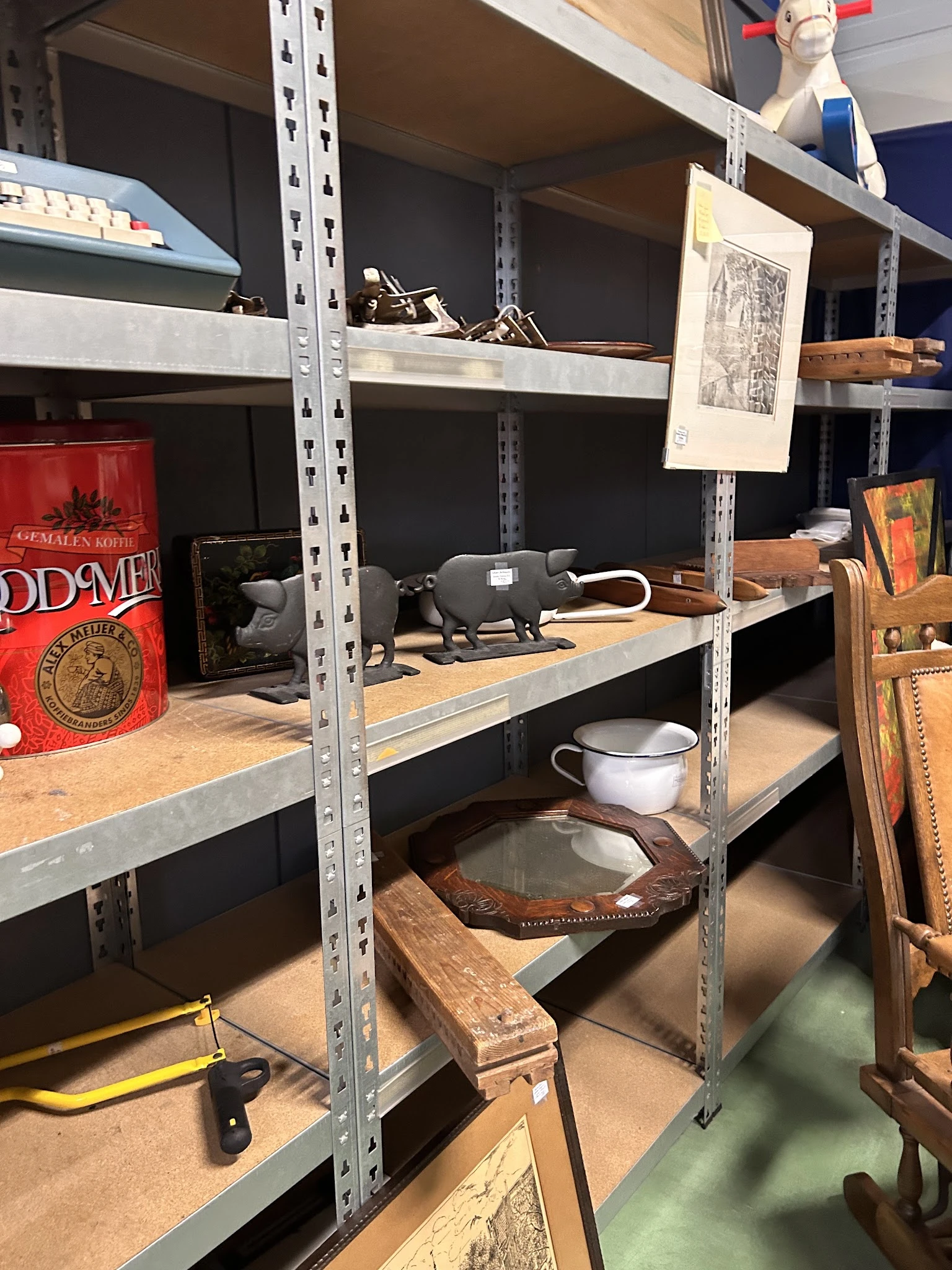 Stellingen met diverse tweedehands spullen: boeken, servies, huishoudelijke artikelen en decoratieve objecten