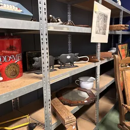 Stellingen met diverse tweedehands spullen: boeken, servies, huishoudelijke artikelen en decoratieve objecten
