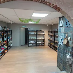 Winkelvloer met stellingen vol spullen, bakstenen muur en plafond met skylight