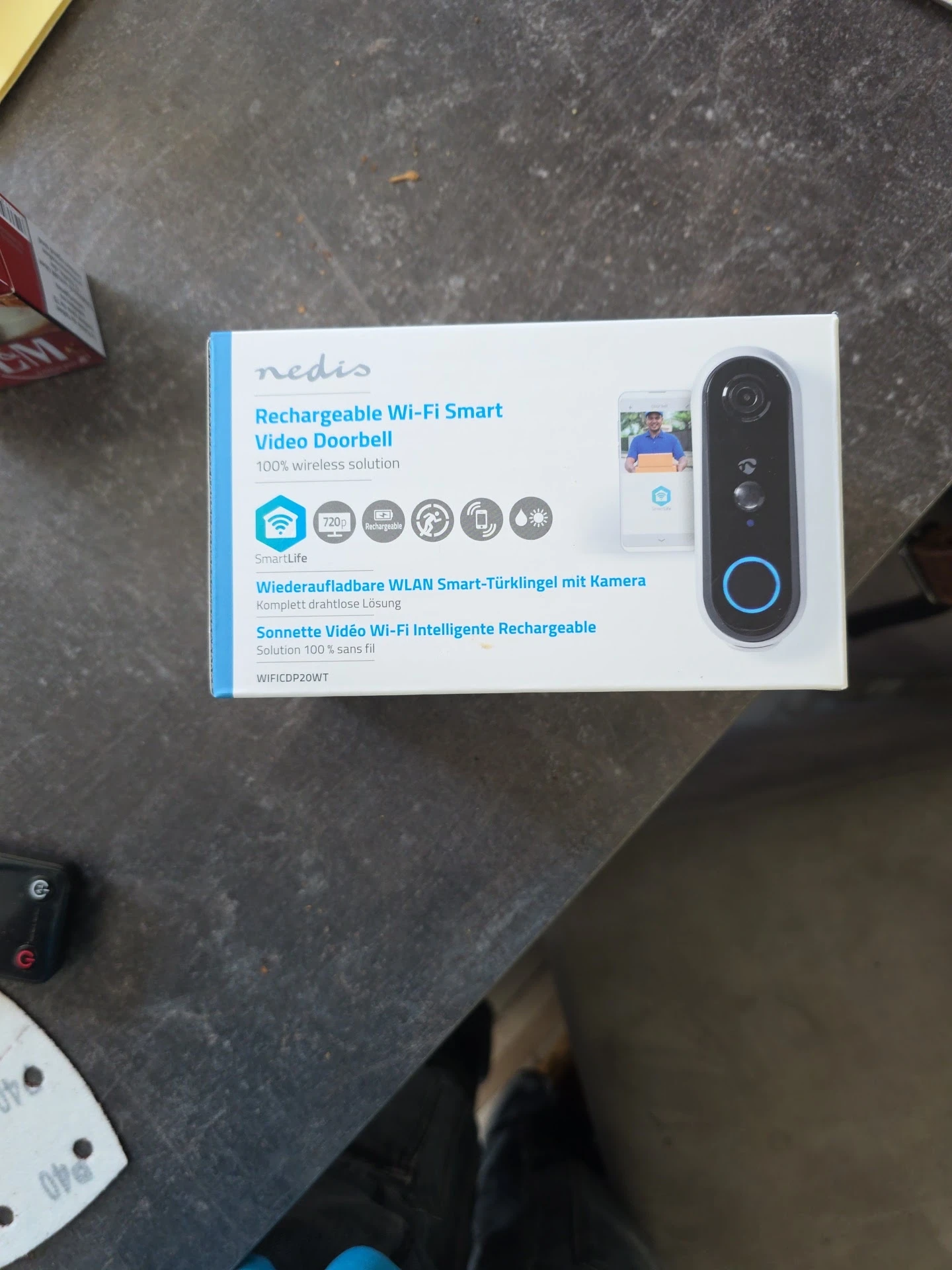 Verpakking van een draadloze Wi-Fi slimme deurbel met camera op grijze ondergrond