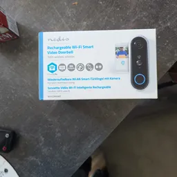 Verpakking van een draadloze Wi-Fi slimme deurbel met camera op grijze ondergrond