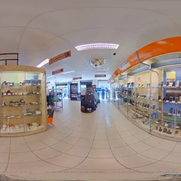 Winkelvloer met stellingen vol producten, toonbanken met oranje boven, moderne verlichting en keramische vloer