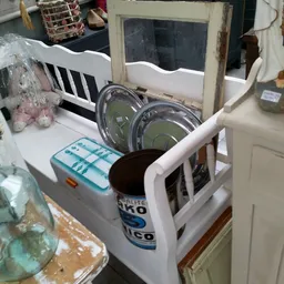 Tweedehands huishoudelijke artikelen op een tafel, waaronder een magnetron, borden en andere keukenspullen