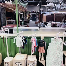 Kinderkledingafdeling met uitgestalde babykleding en kinderoutfits op hangers en paspop