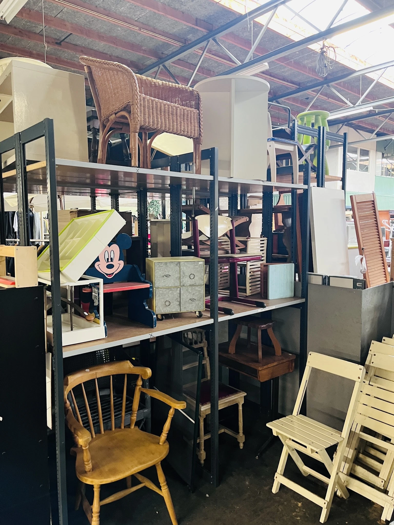 Kringloopwinkel interieur met stellingen vol meubels, stoelen en huishoudelijke spullen